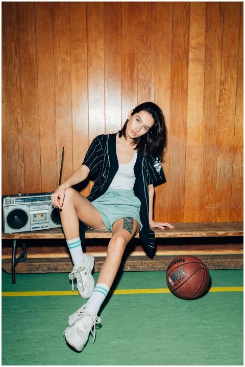 A stylish woman in a vintage gym setting, sitting