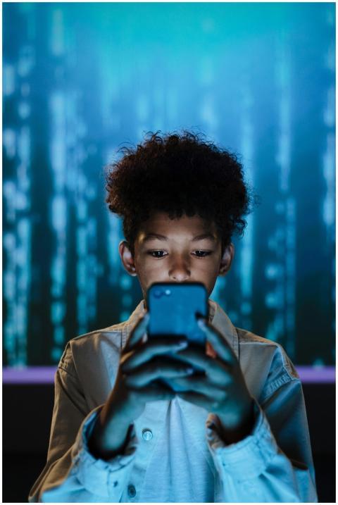 Boy focused on using a smartphone with a tech-insp