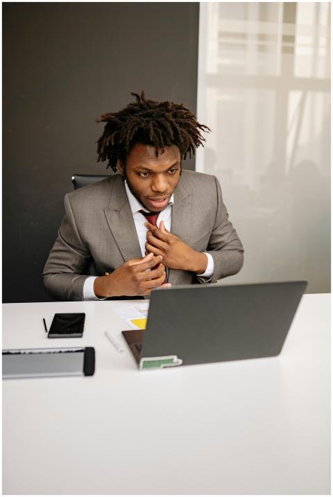 A young businessman with dreadlocks works intently