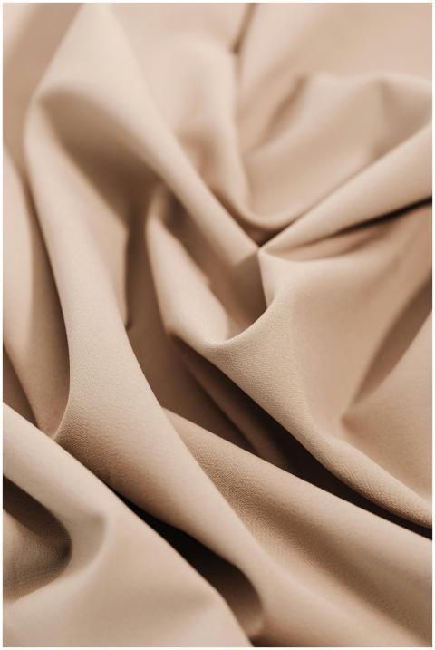 Soft beige textile fabric close-up showing intrica