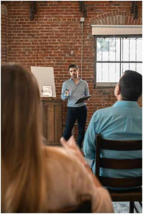 Man teaching an adult education class with brick w