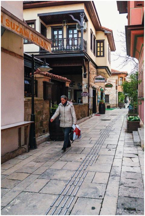Woman walks through a quaint historic street, with