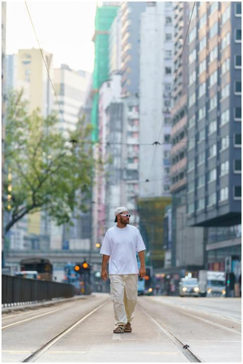 A man casually strolling through a busy street in