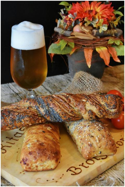 Artisan bread with a frothy beer and autumn flower