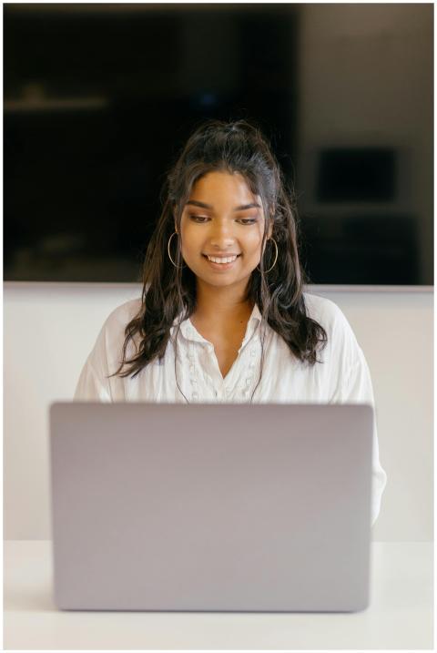 A teenager studying indoors with a laptop, showing