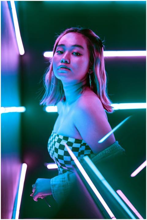 A young woman posing in vibrant neon lighting wear