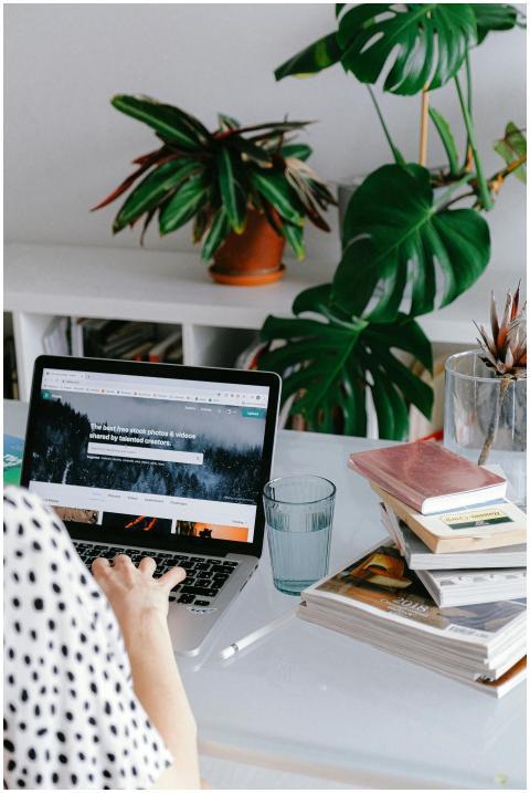 A woman working from home on her laptop surrounded