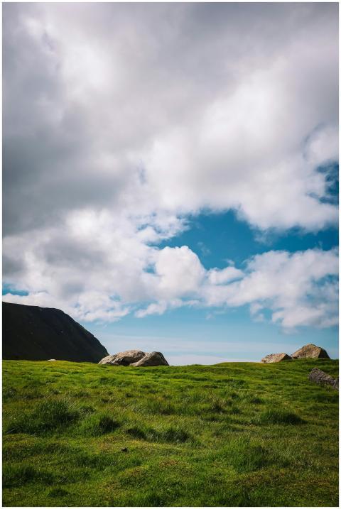 Beautiful grassy landscape with rocks under a clou