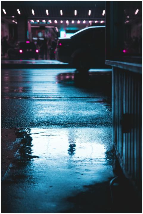 Wet city street reflecting lights in a moody night