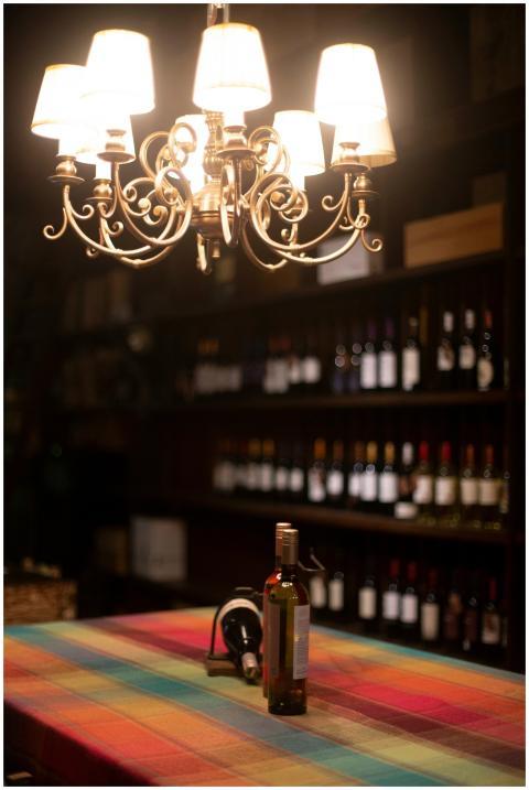 A colorful wine bottle display set under a vintage