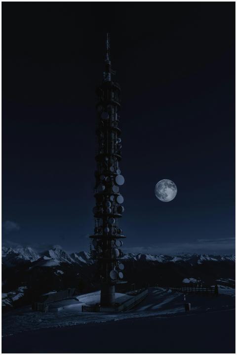 A telecommunication tower silhouetted by a full mo