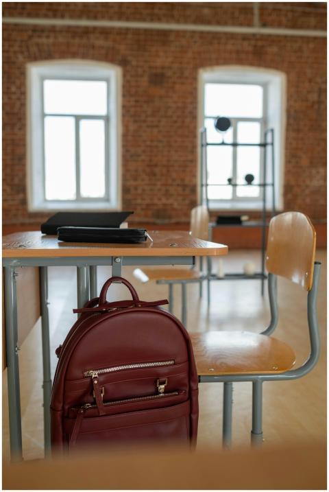 Spacious classroom setting with a backpack on a de