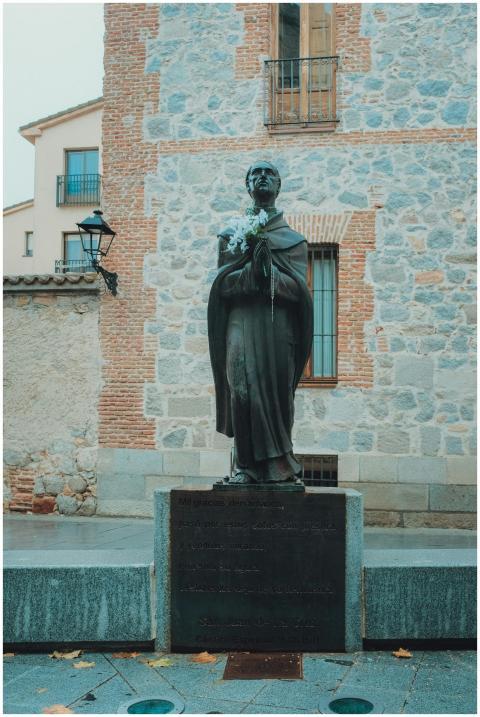 Stone statue in Ávila, Spain against historic bric