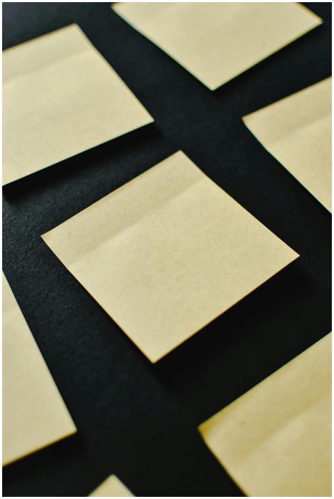 A collection of blank sticky notes arranged on a b