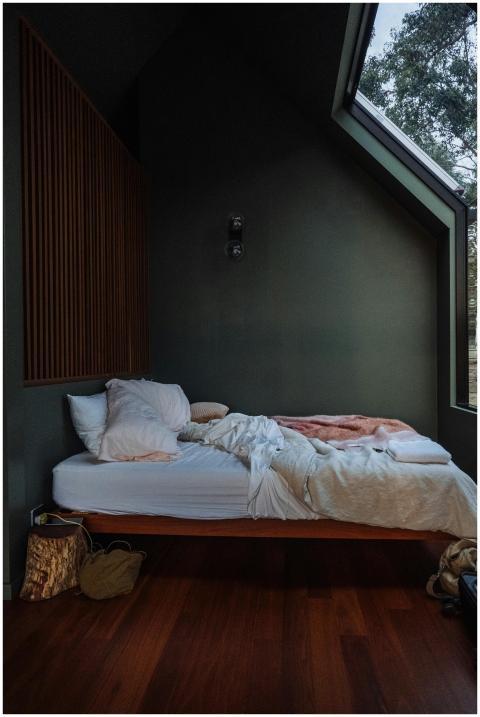 Minimalist bedroom with cozy bed, wooden accents,