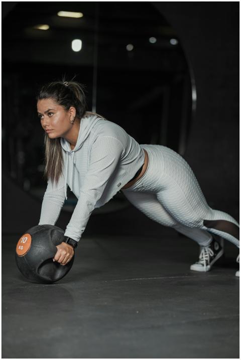 Focused woman exercising with a medicine ball in a