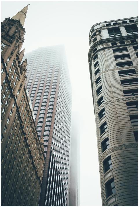 Misty view of skyscrapers reaching into the fog, c