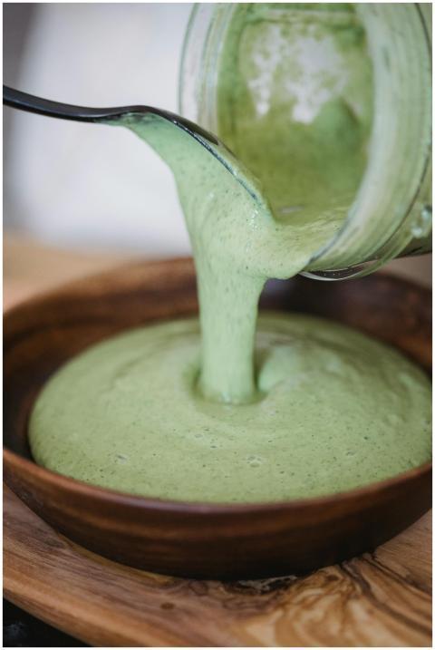 Close-up of creamy green smoothie being poured int