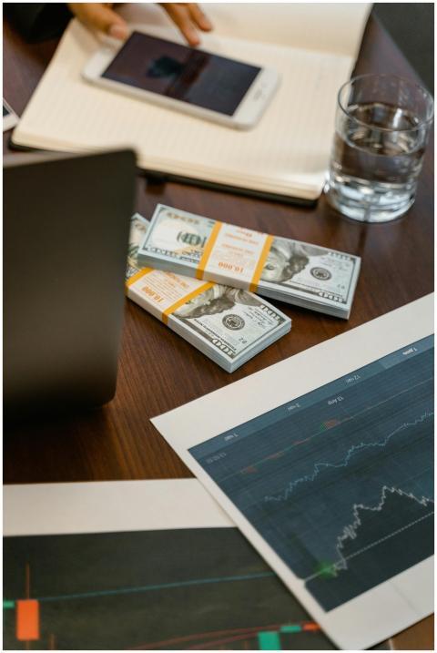 Stacks of US dollars and analytics charts on a woo