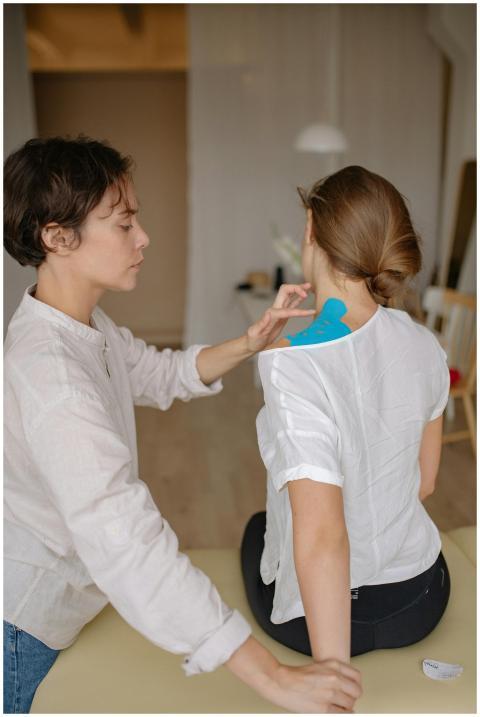 A chiropractor applying therapy tape during a shou