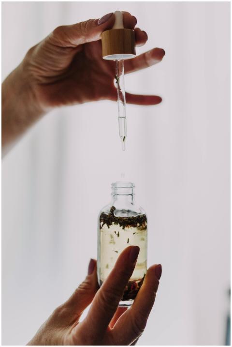 Close-up of hands using a dropper with an essentia