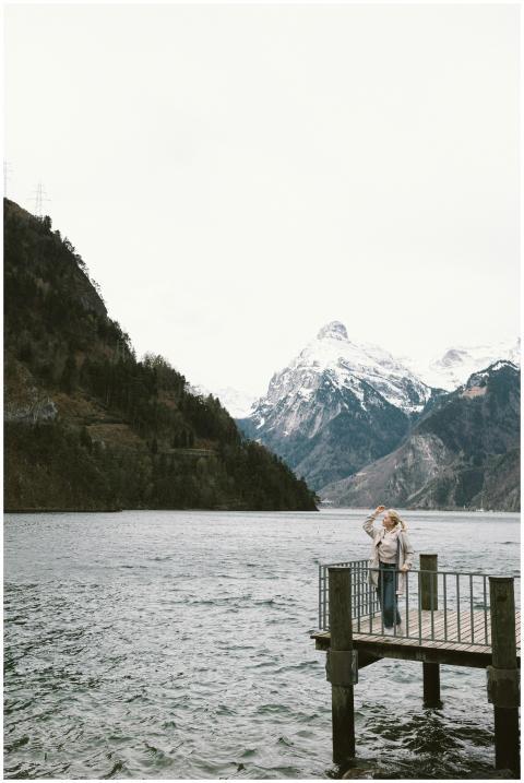Woman standing on a pier by a tranquil lake with s
