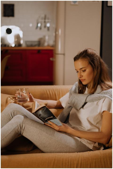 A woman enjoys a quiet evening reading on the sofa