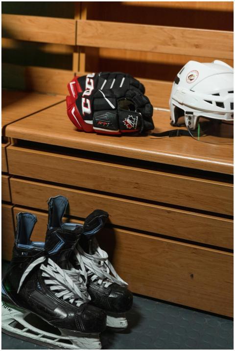 Hockey helmet, skates, and gloves on wooden bench
