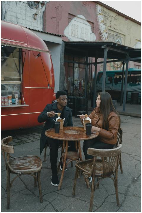 Interracial couple enjoying street food outside a