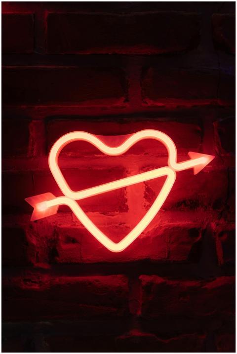 Bright neon heart with arrow sign on a rustic bric
