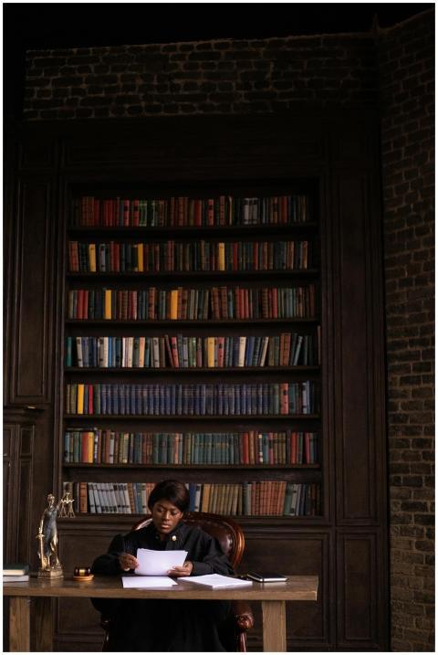 Black female judge reading papers at desk in offic