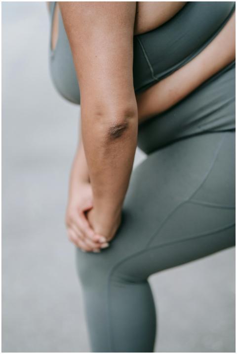 Woman in sports clothing bending over and touching