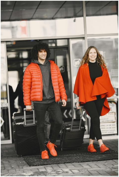 A cheerful couple exiting an airport terminal with