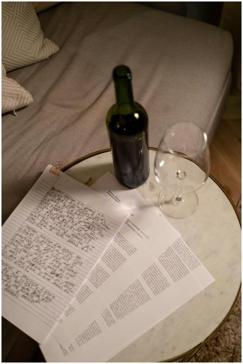 A casual setup of wine and documents on a round ma