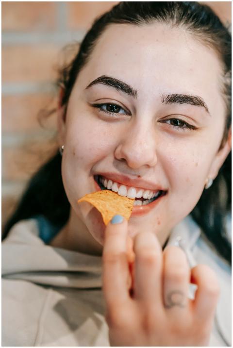 Smiling woman savoring a delicious chip with joy i