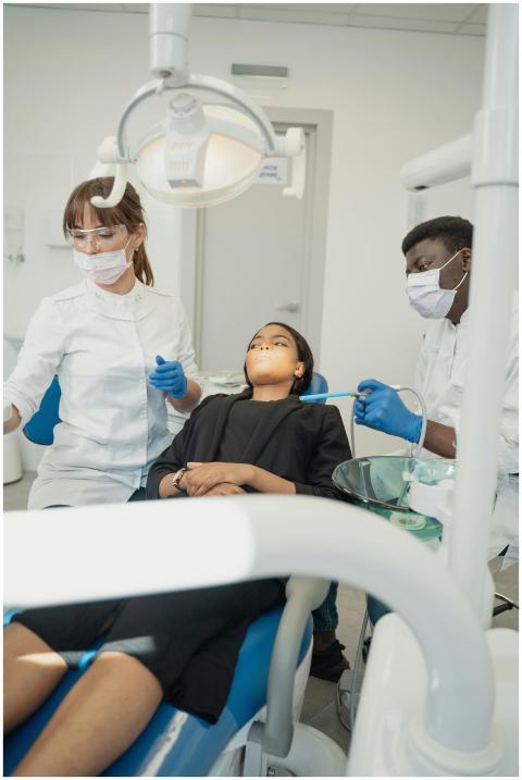A dentist and assistant examine a patient in a mod