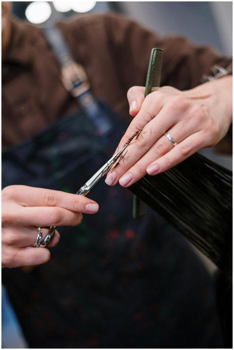 A professional hairstylist cutting hair in a salon