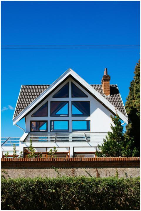 A modern A-frame house with large windows against