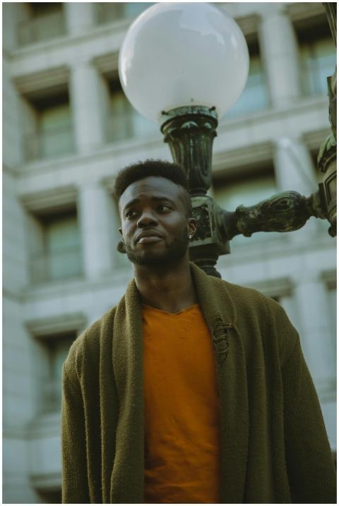 Pensive African American male in stylish outfit lo