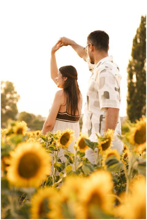 A loving couple dances amidst a vibrant sunflower