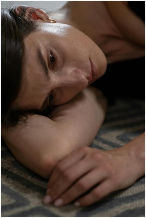 Close-up of a woman lying down, expressing sadness