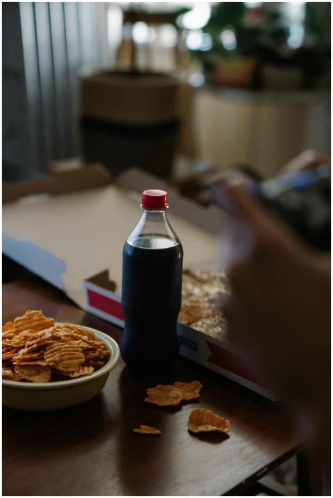 A cozy indoor setting featuring soda, pizza, and c