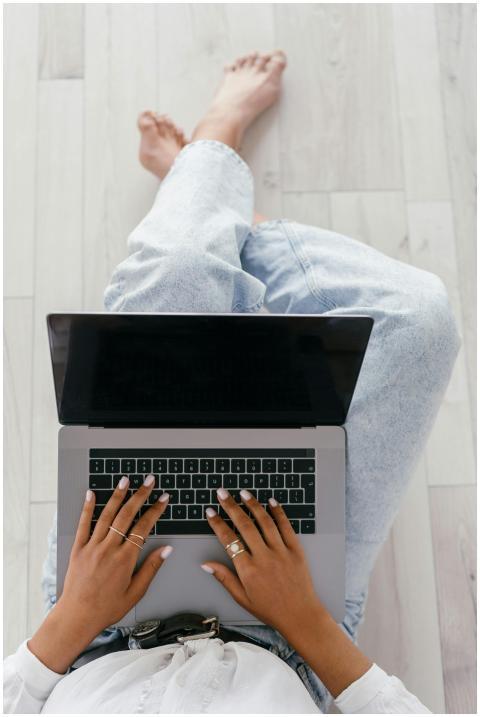 Overhead view of a woman typing on a laptop while