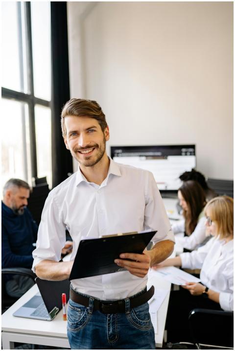 Professional man smiling while holding clipboard i