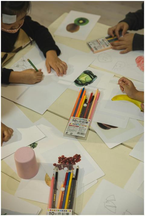 Kids drawing with colored pencils at a table, enha