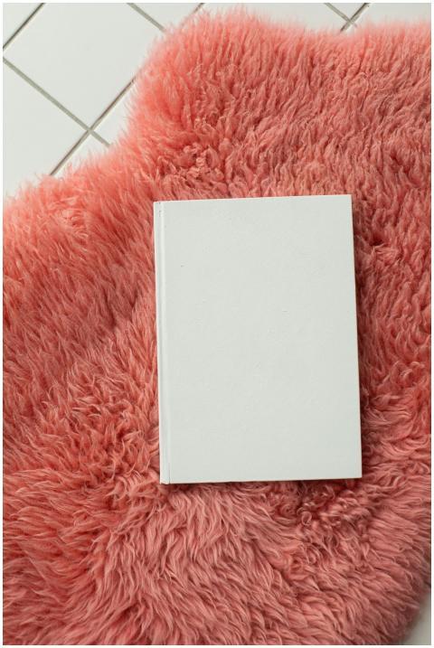 From above of notebook with white blank cover plac