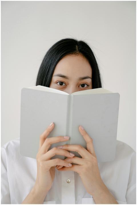Young woman with book in studio setting, showcasin