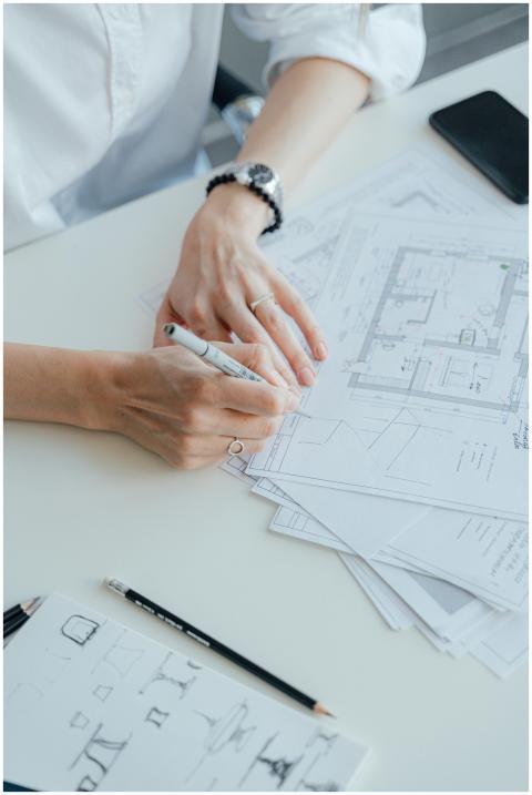 An architect writes notes on design plans while si