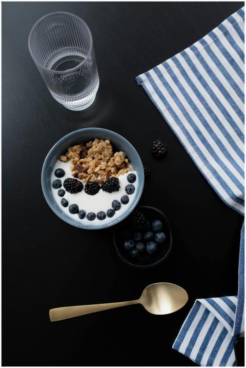 A healthy breakfast bowl with granola, blackberrie