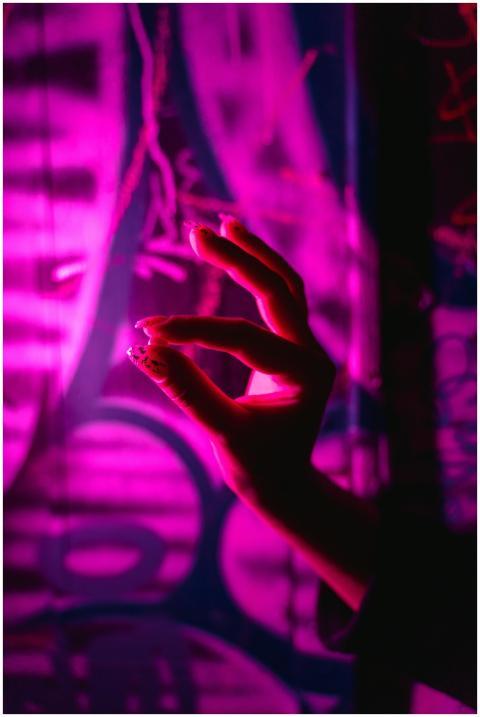 A silhouette of a hand gesturing against vibrant n